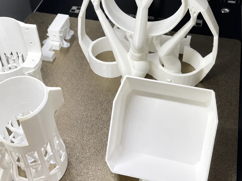 Close-up of freshly printed white 3D-printed parts on the build plate