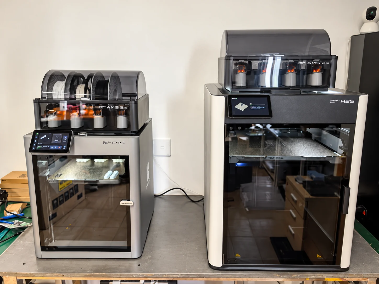 Enclosed 3D printers on a workbench in our workshop