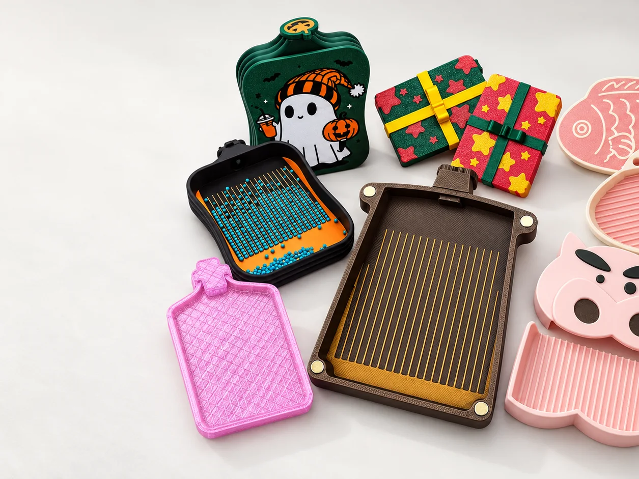 3D-printed craft tool collection including themed diamond painting trays and a magnetic sliding tray