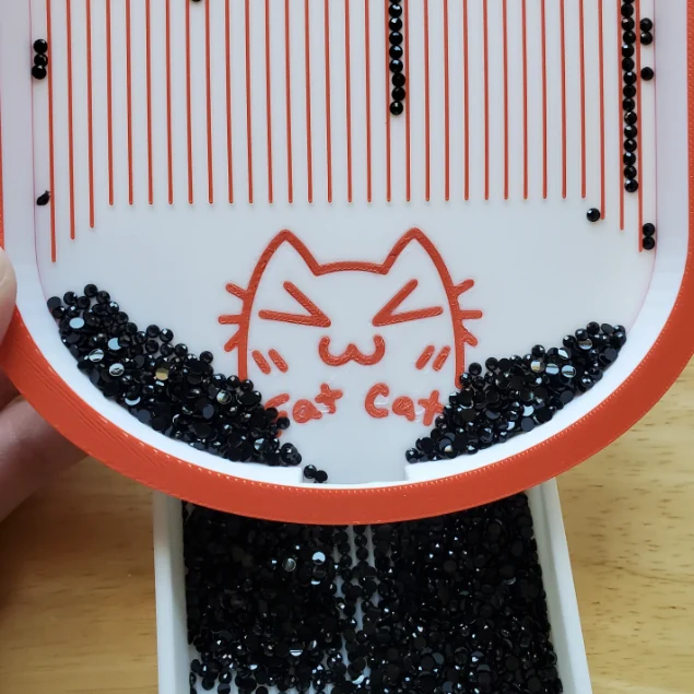 Diamond painting tray in use with black diamonds sorted into the grooves